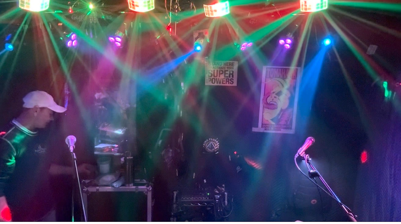 Practice room lit up by green and magenta beams during a light-rig test